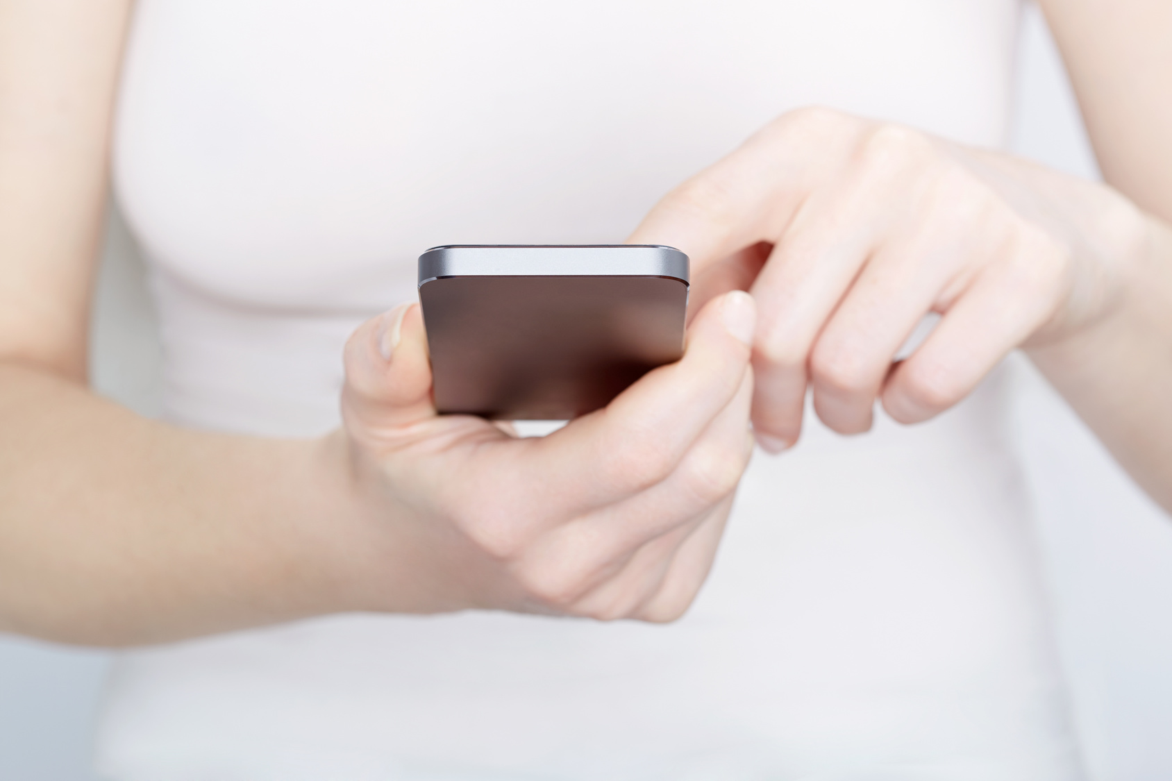 Close up of woman in white using a smartphone