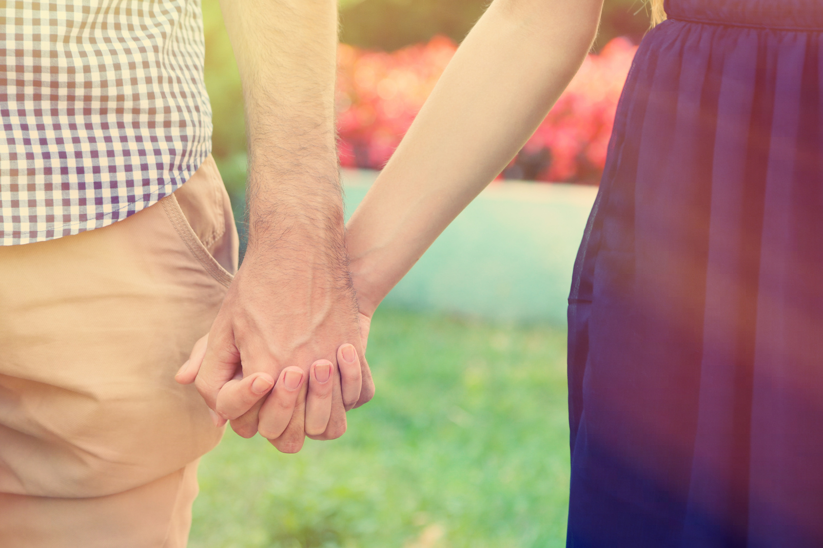 Young couple holding hands, outdoors