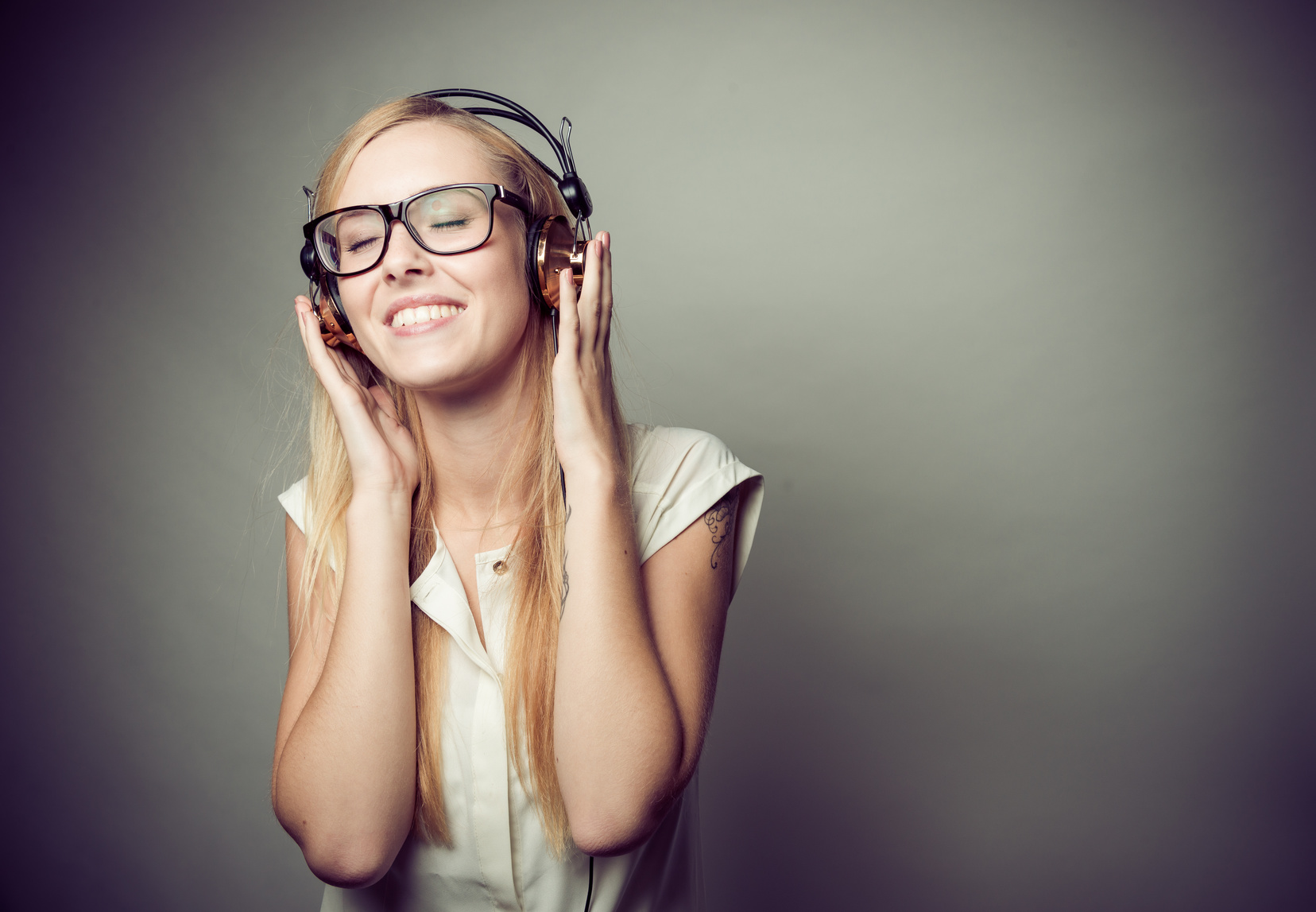 young blonde woman enjoying music on headphones