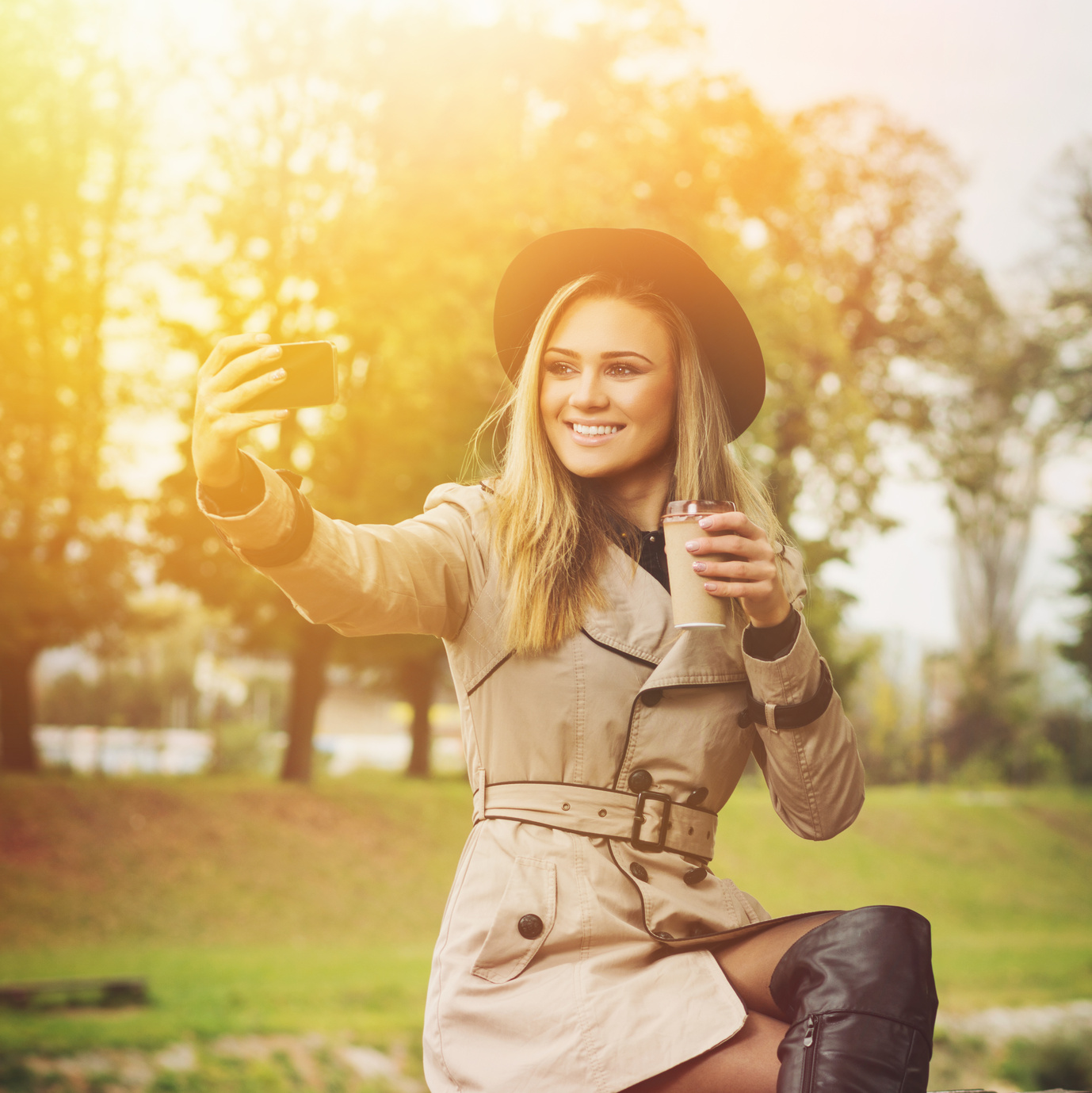 Gorgeous stylish young woman taking a selfie outdoors in autumn