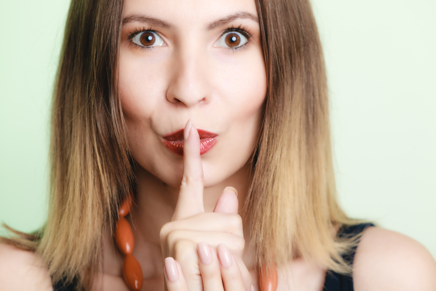 Woman asking for silence with finger on lips secret