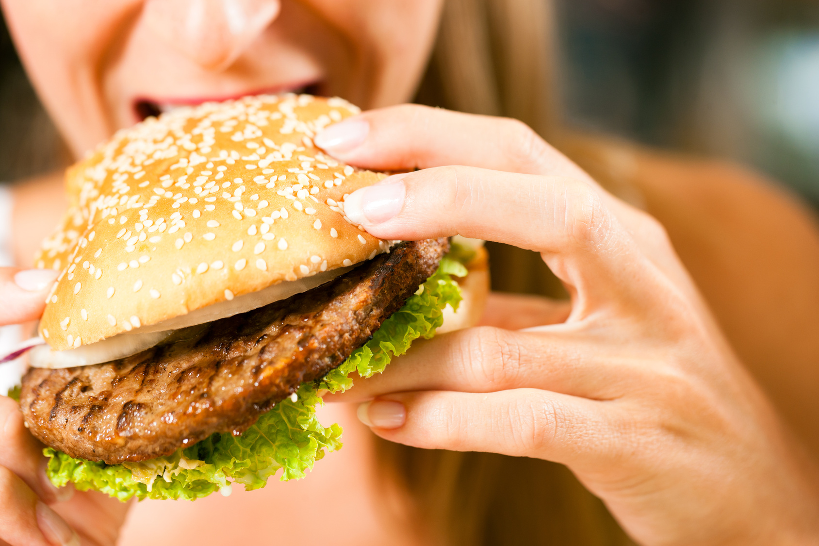 Frau im Restaurant isst Hamburger