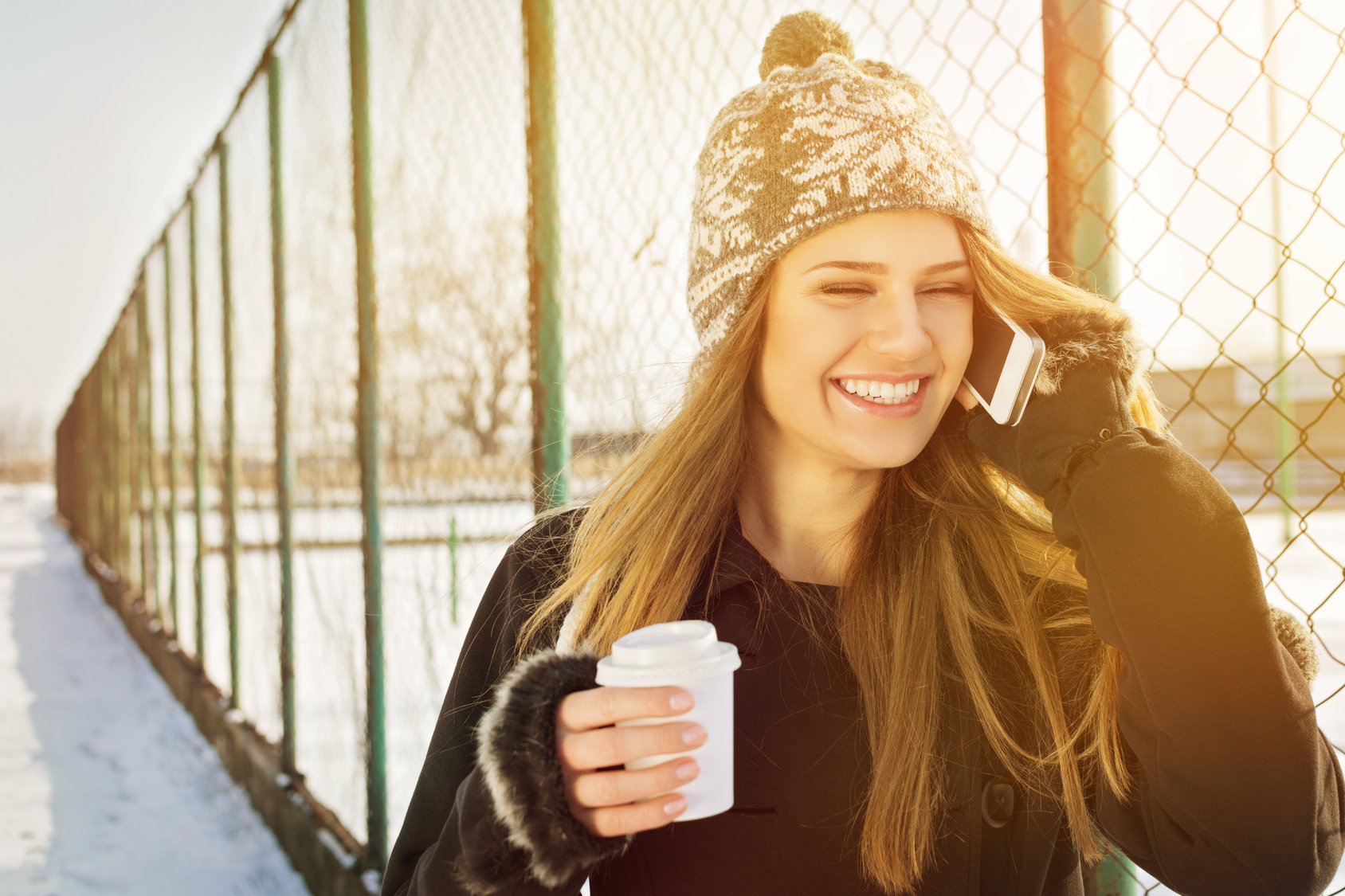 Happy young woman talking on the phone laughing