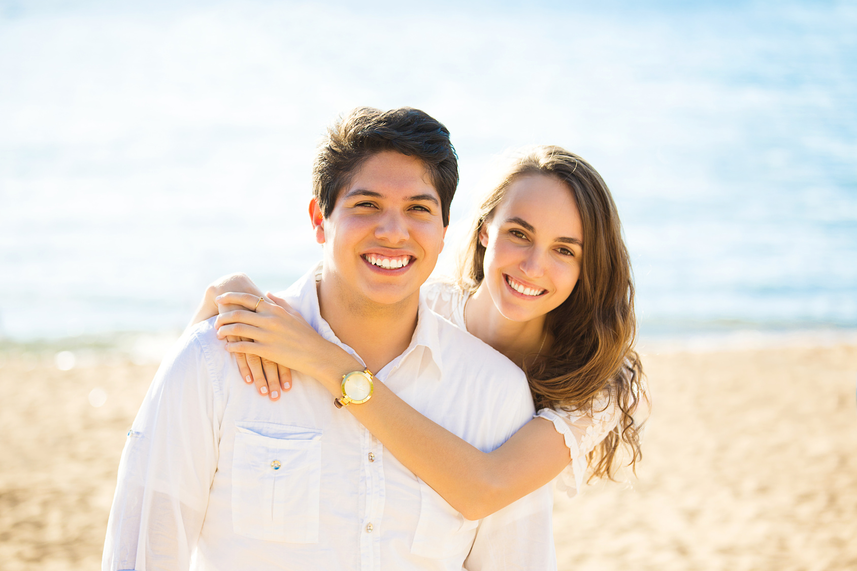 Smiling couple by the sea on sunny summer, autumn day