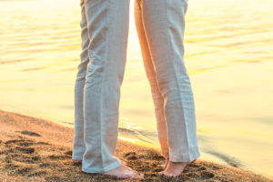 bare feet kissing couple at the sea