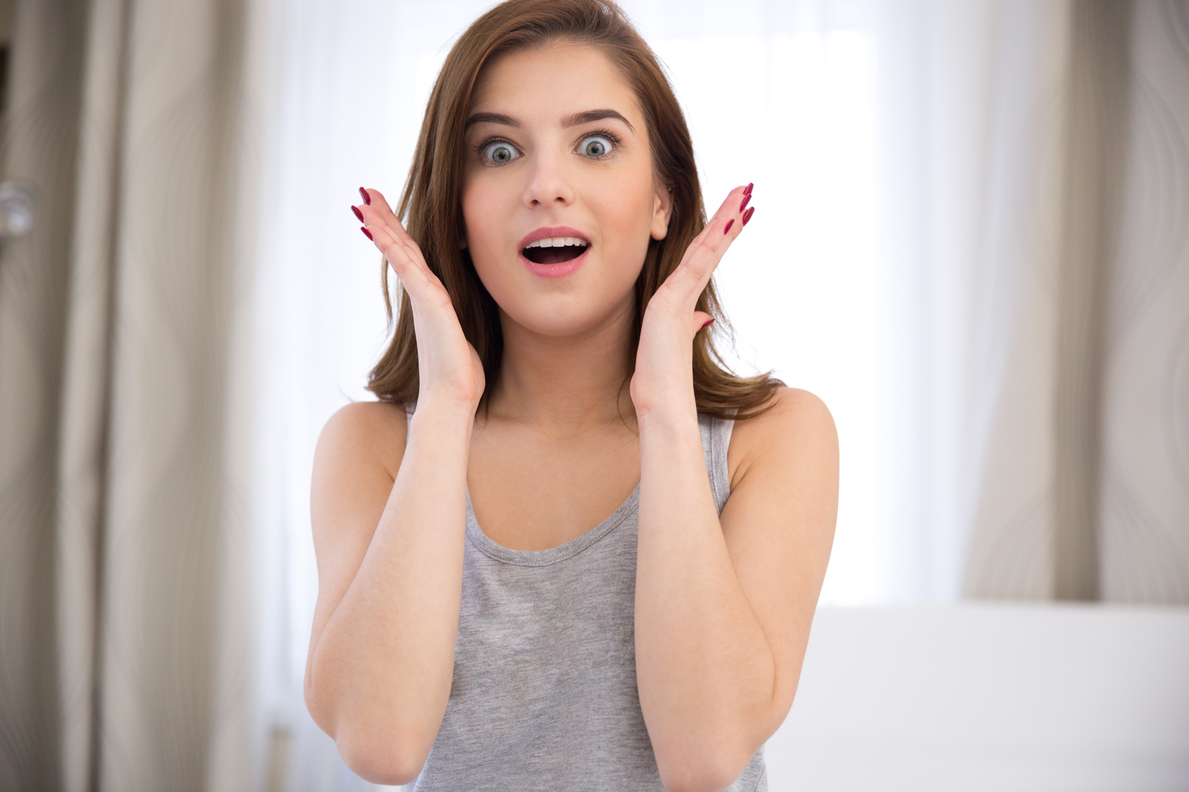 Portrait of a young surprised woman at home