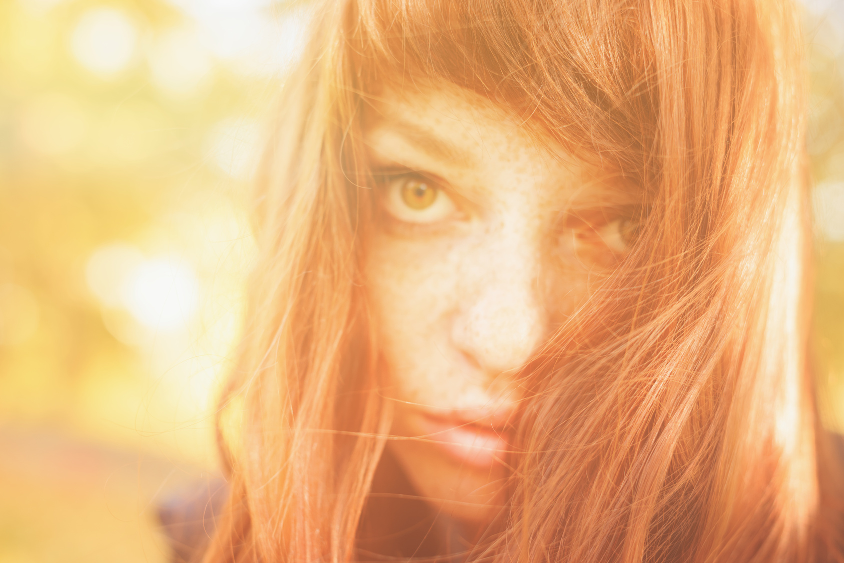woman with freckles and red long hair in fall park