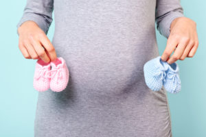 Pregnant woman holding baby booties
