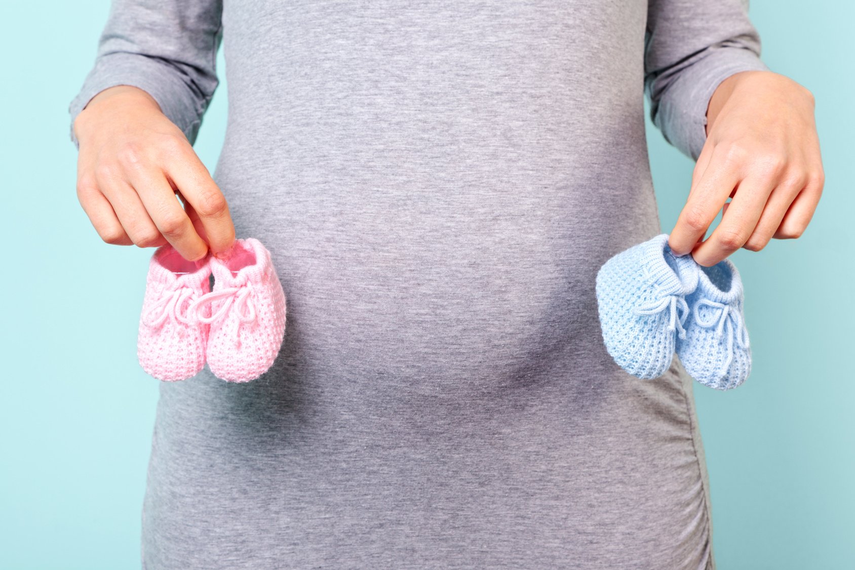 Pregnant woman holding baby booties