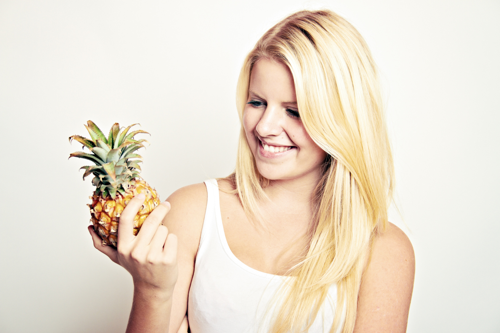 woman is holding a little pineapple