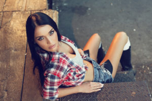 Beautiful young woman with black hair and blue eyes posing