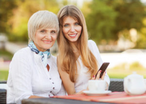 adult mother and daughter drinking tea or coffee