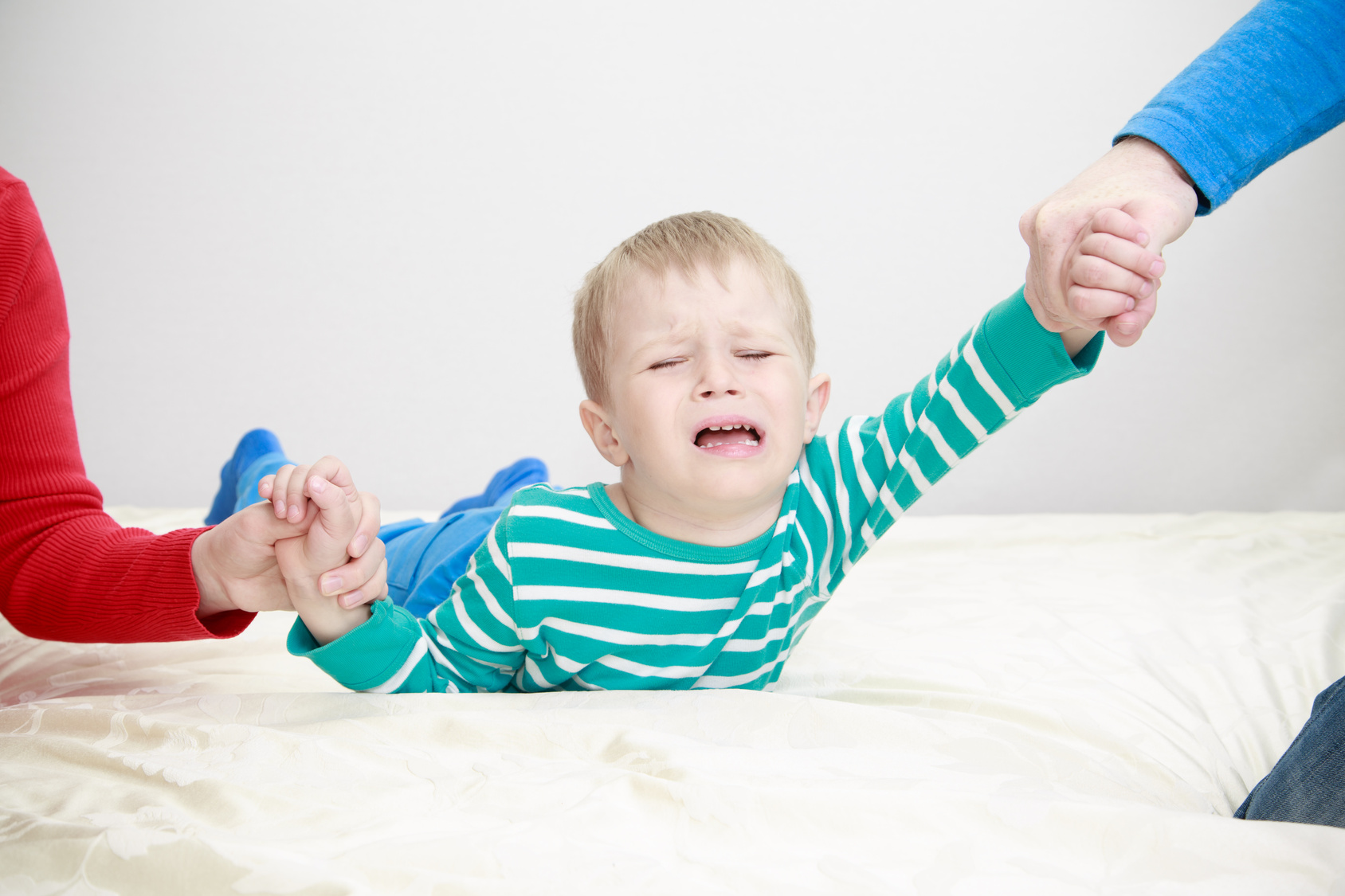 divorced parents holding sad child separately