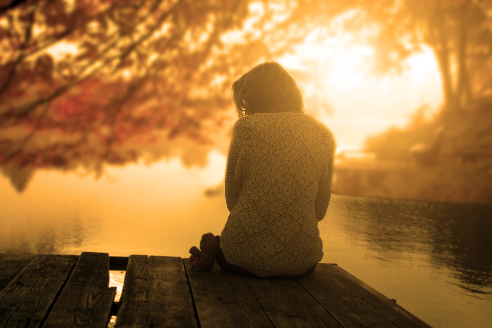 Woman relaxing at the lake in sunset