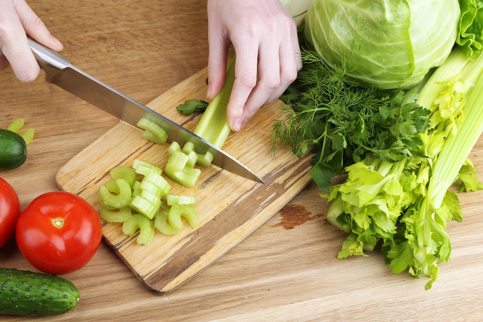 Female hands cutting celery