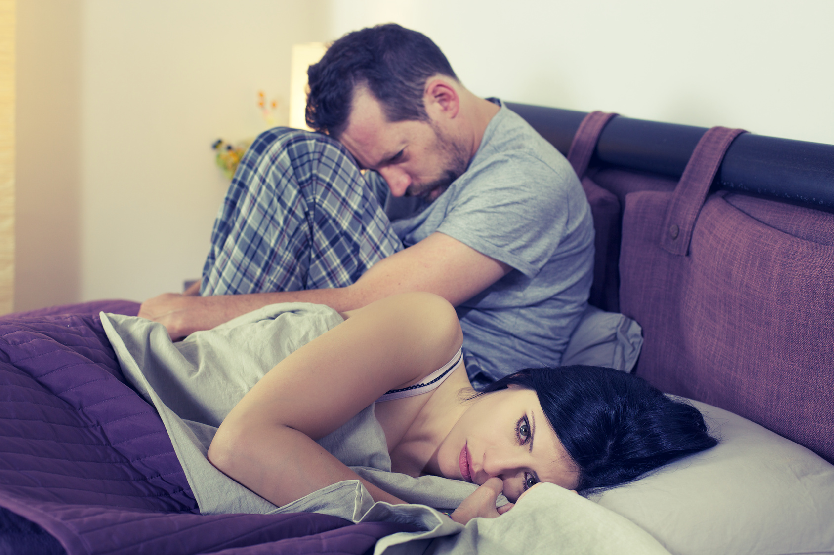 Sad couple in crisis at home in bed