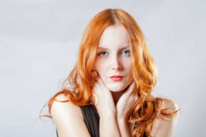 beauty shot of a young blue eyed woman with her red hair