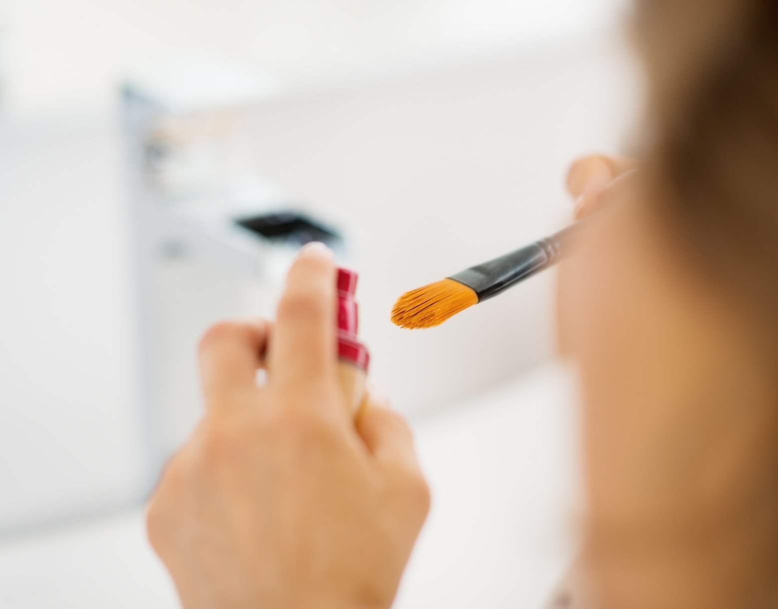 Closeup on young woman using makeup