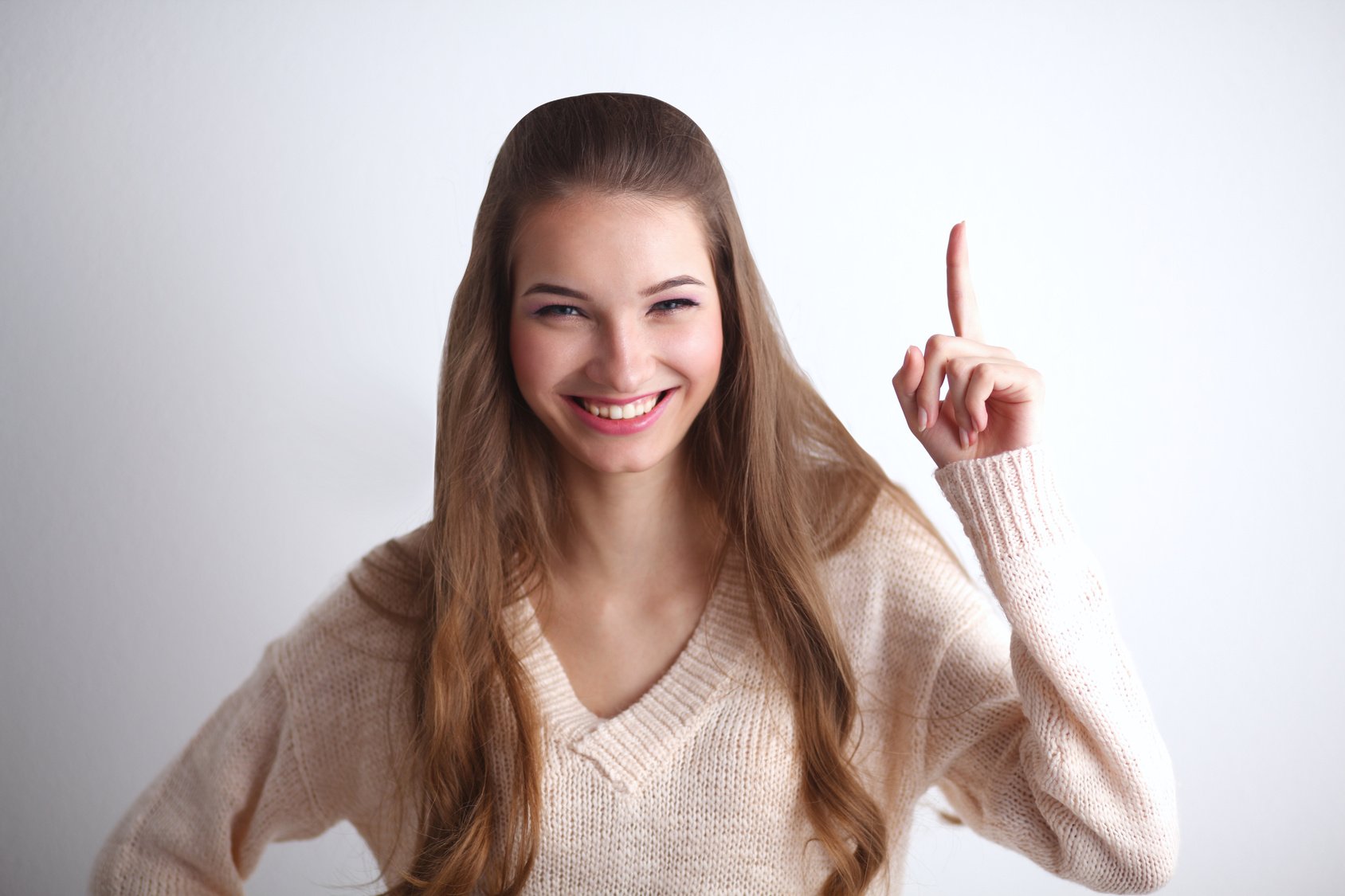 Portrait of a smiling young woman pointing up