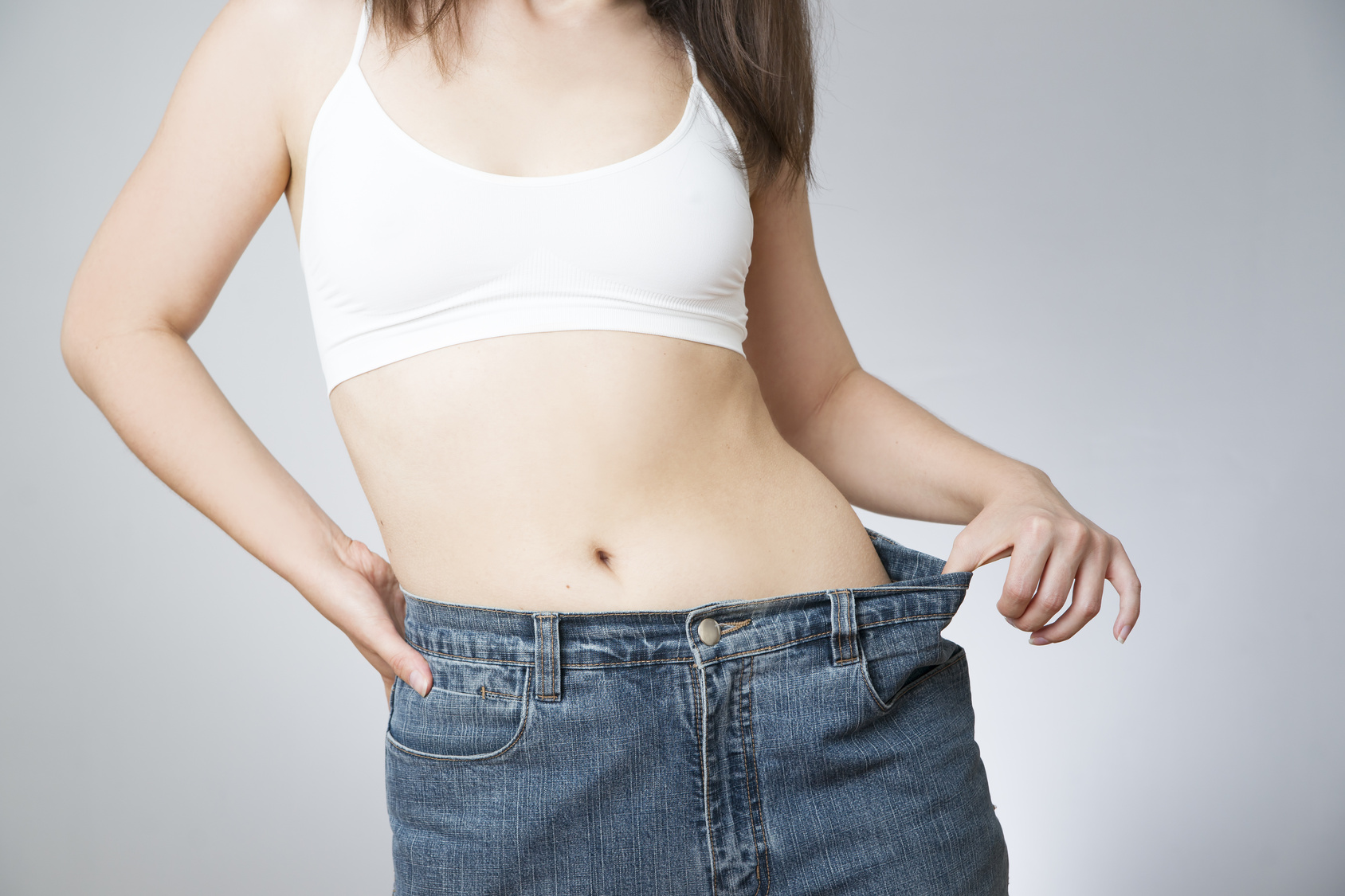 Young woman in jeans of large size, concept of weight loss