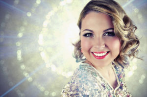 Smiling woman with short blonde curly hair.
