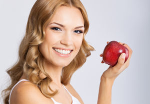 Woman with apple, on grey