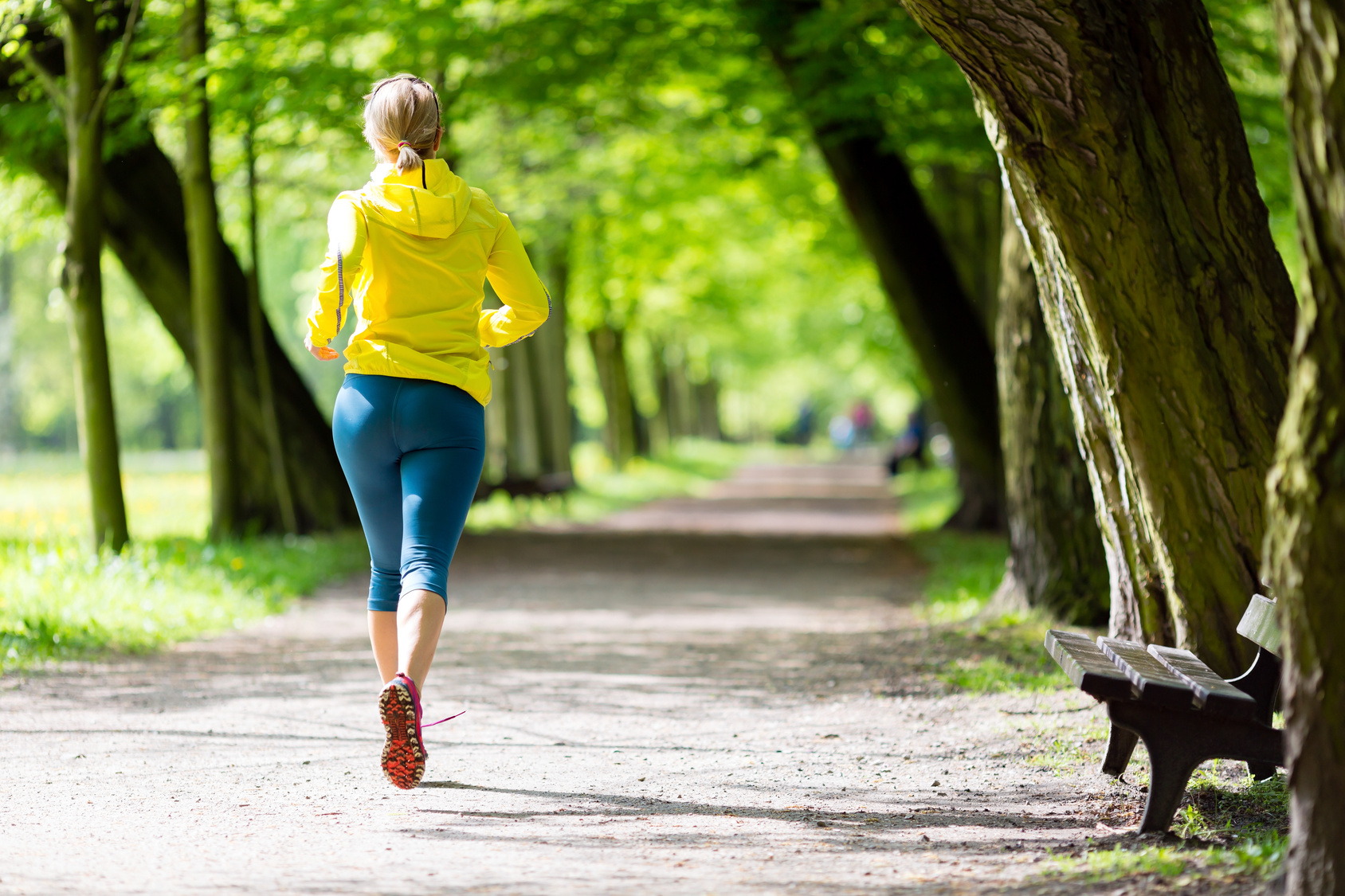 Woman runner running jogging in summer park