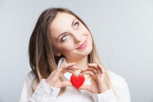 Portrait of a cheerful female holding a heart