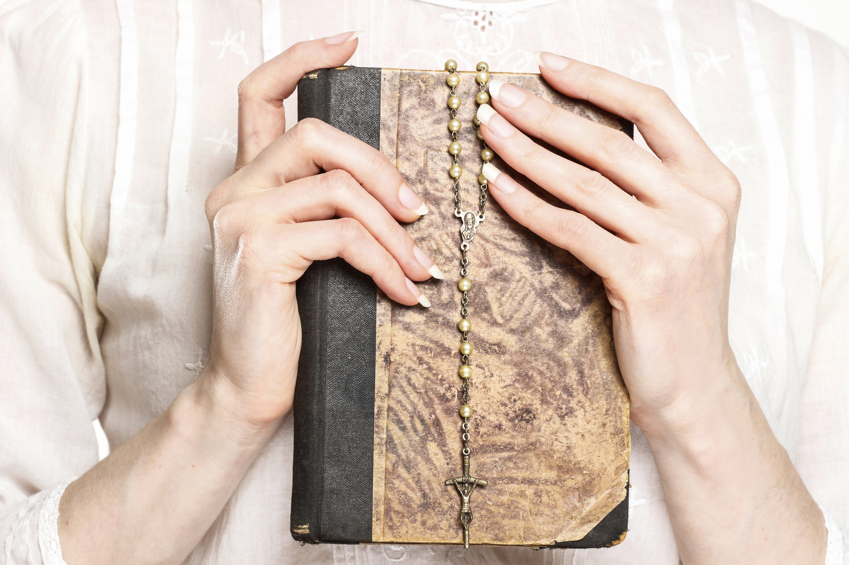 Young woman holding a Holy Bible and rosary