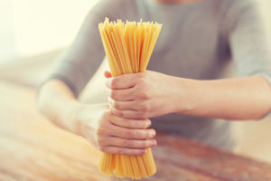 close up of female hands holding spaghetti pasta