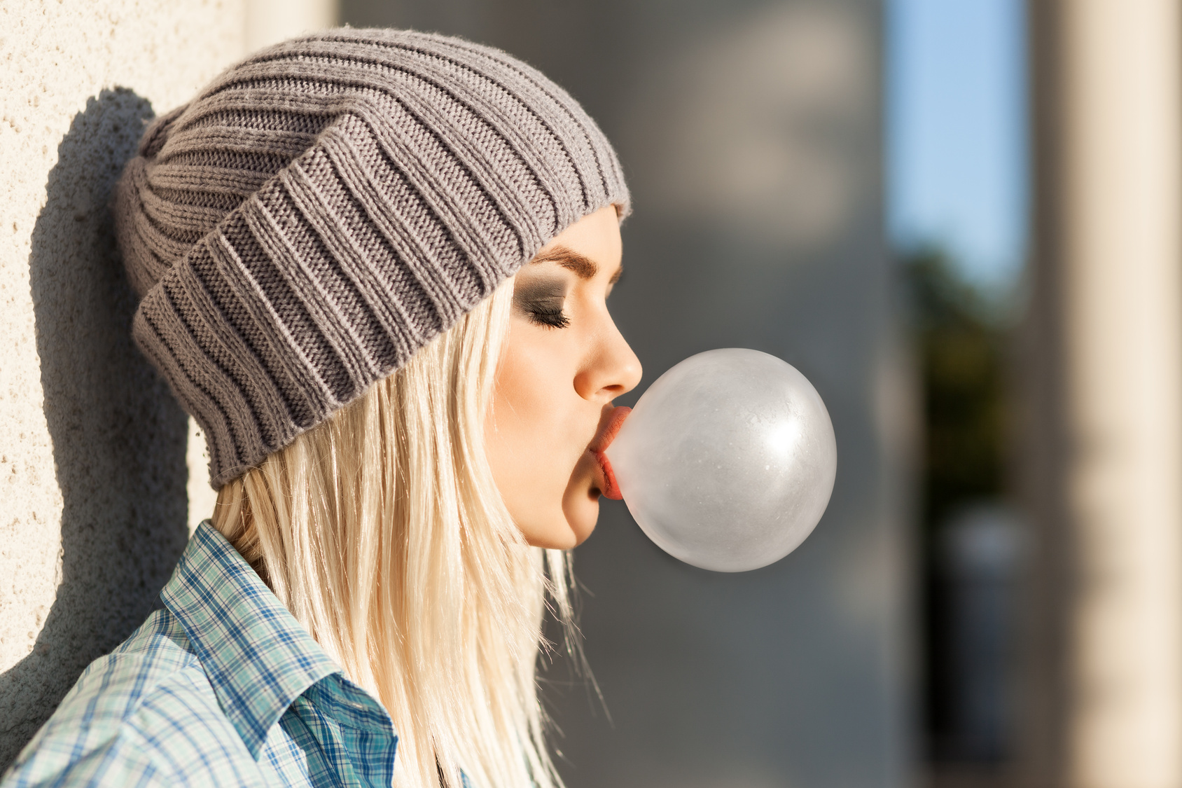 Beautiful blonde girl in beanie hat with smokey eye make up who