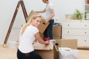 junge frau packt umzugskartons aus