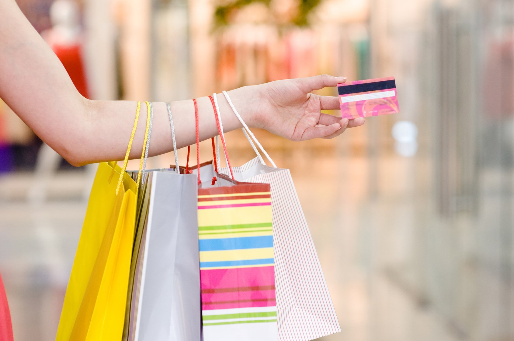 Female hand holding shopping bags and credit card