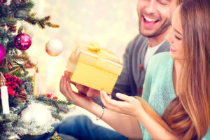 Happy Couple with Christmas Gift at Home