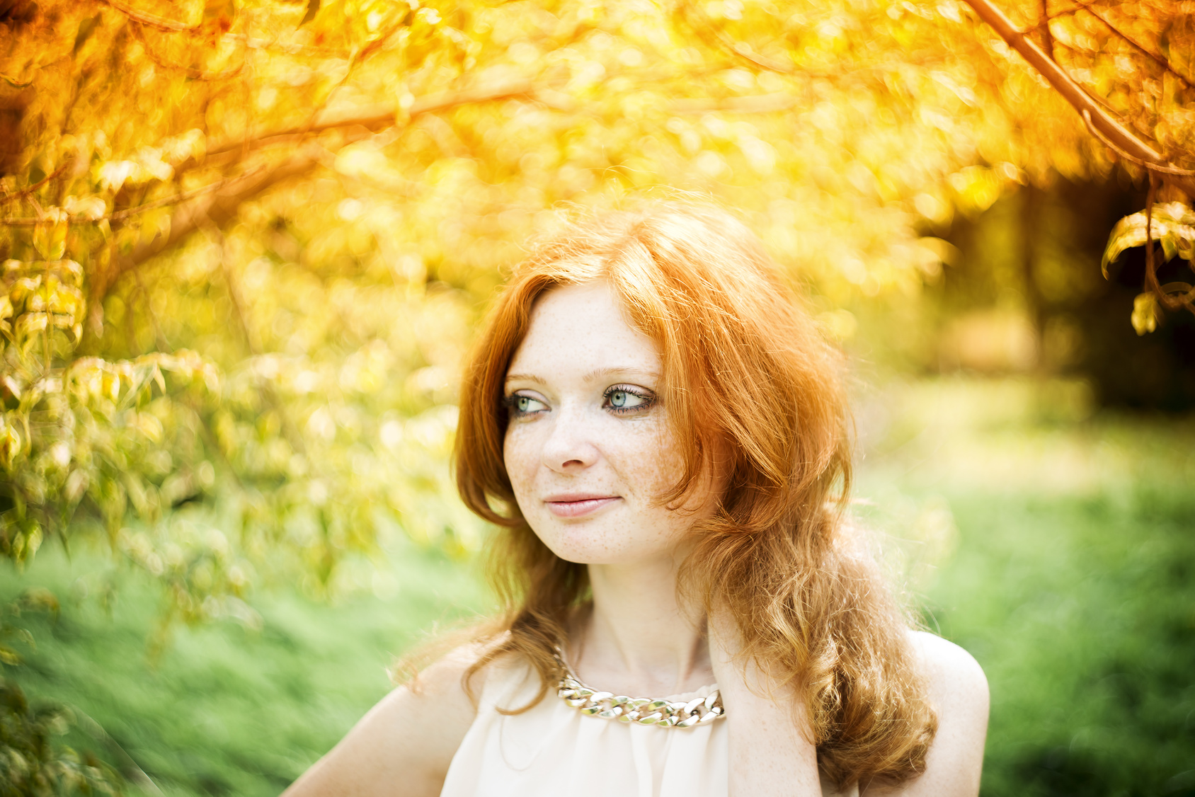 Portrait of redhead girl with blue eyes on nature
