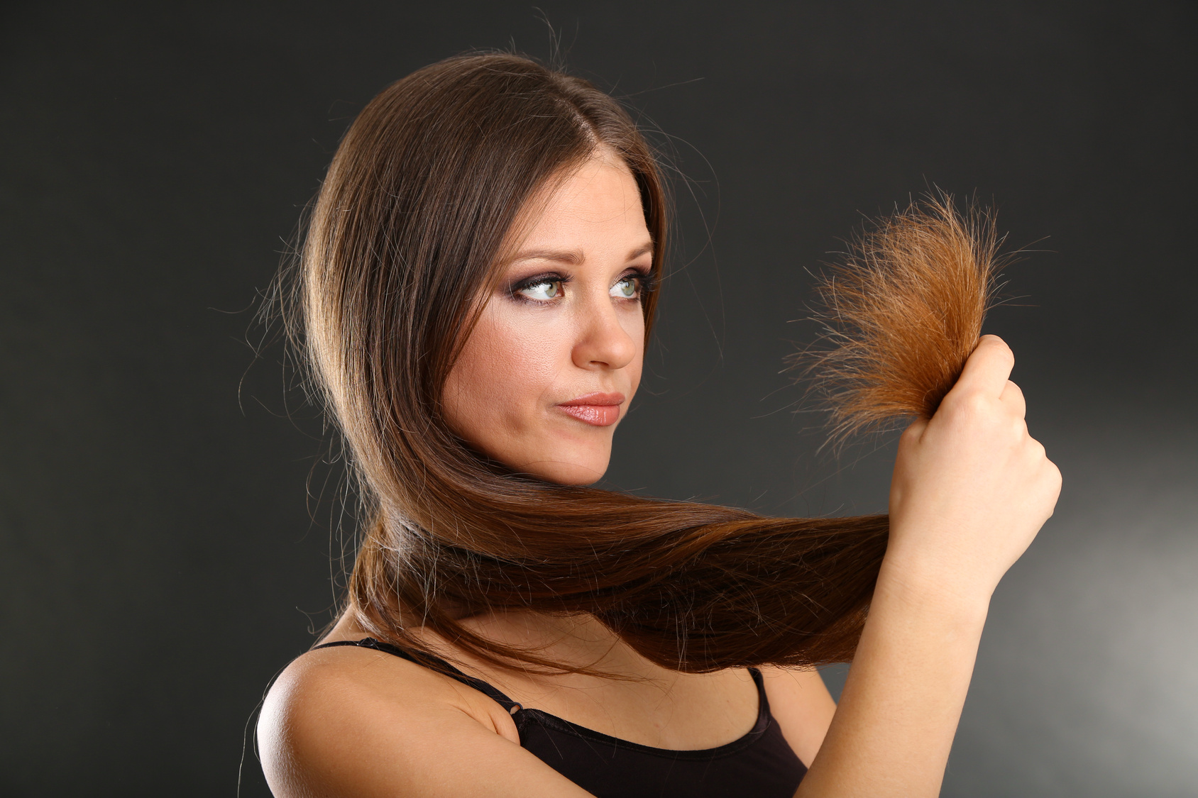 Beautiful woman holding split ends of her long hair,