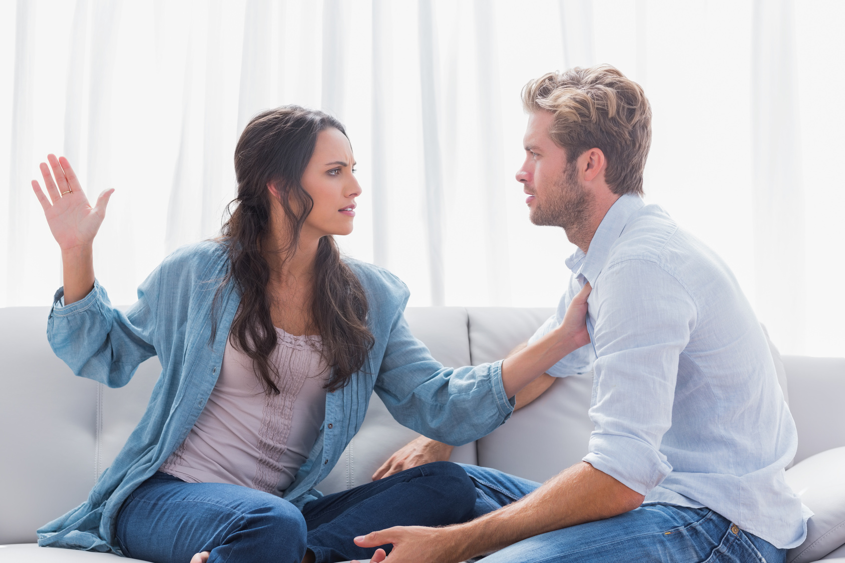 Angry woman about to slap her partner in living room