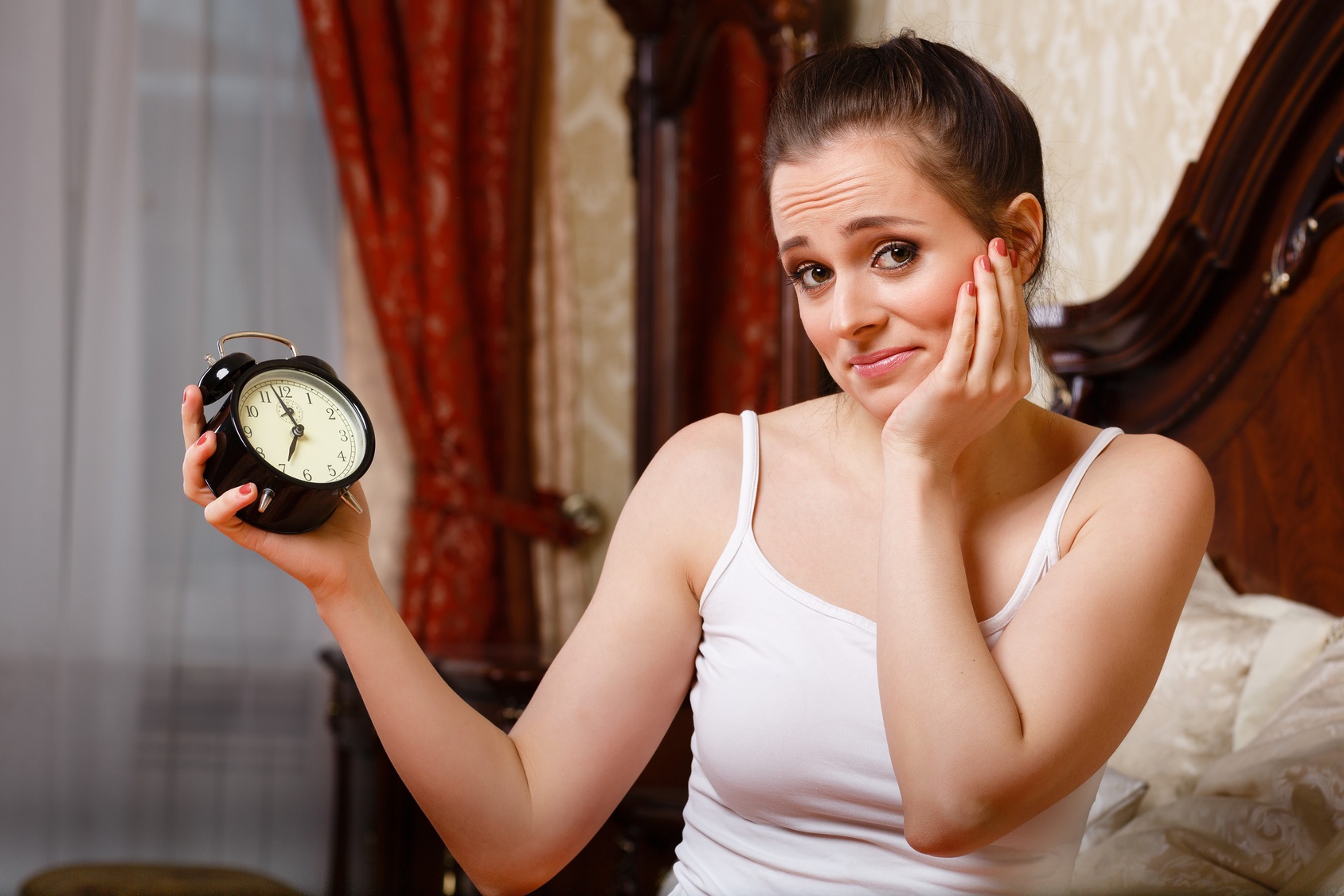 Young woman with alarm clock.