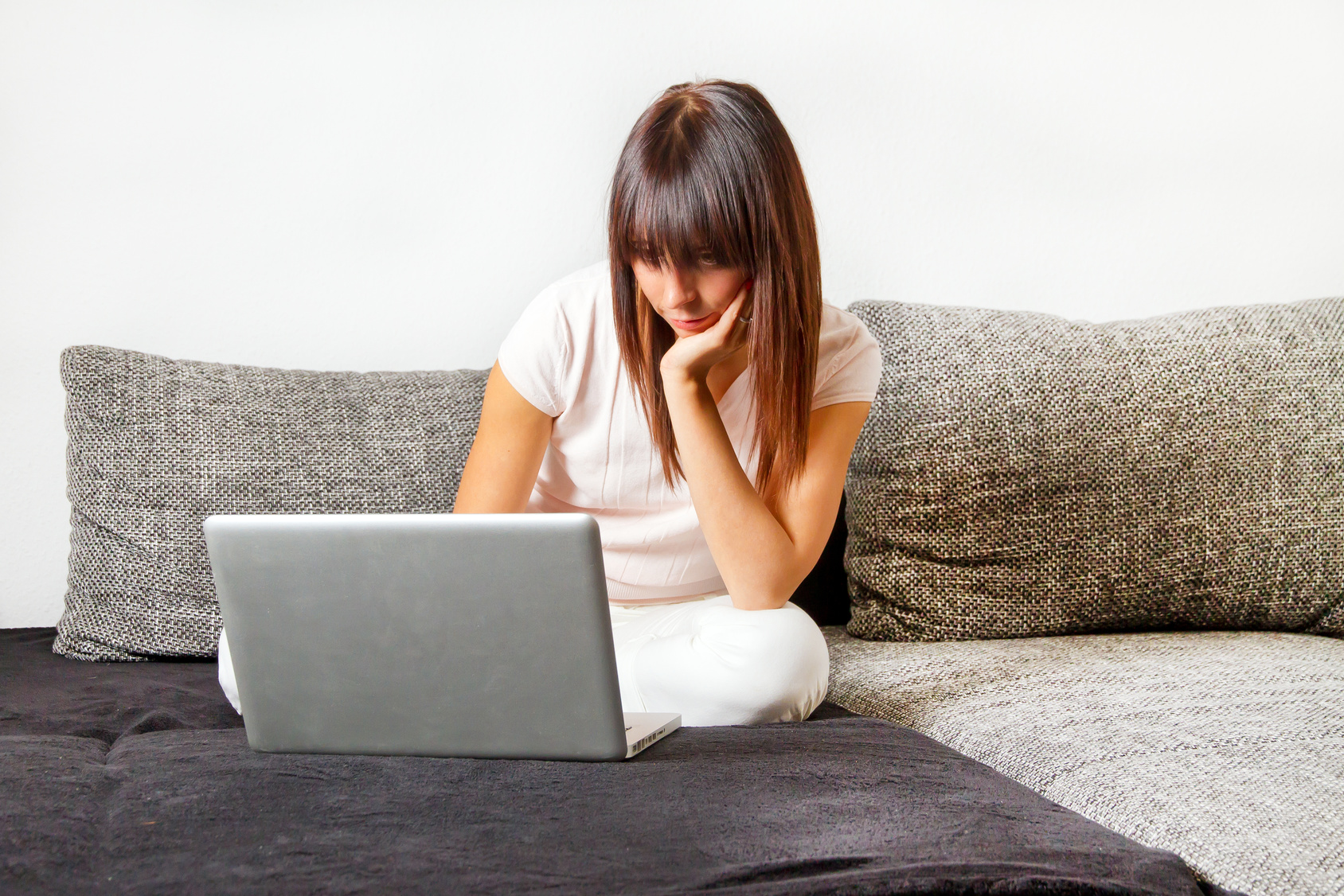 Young woman with laptop on a couch