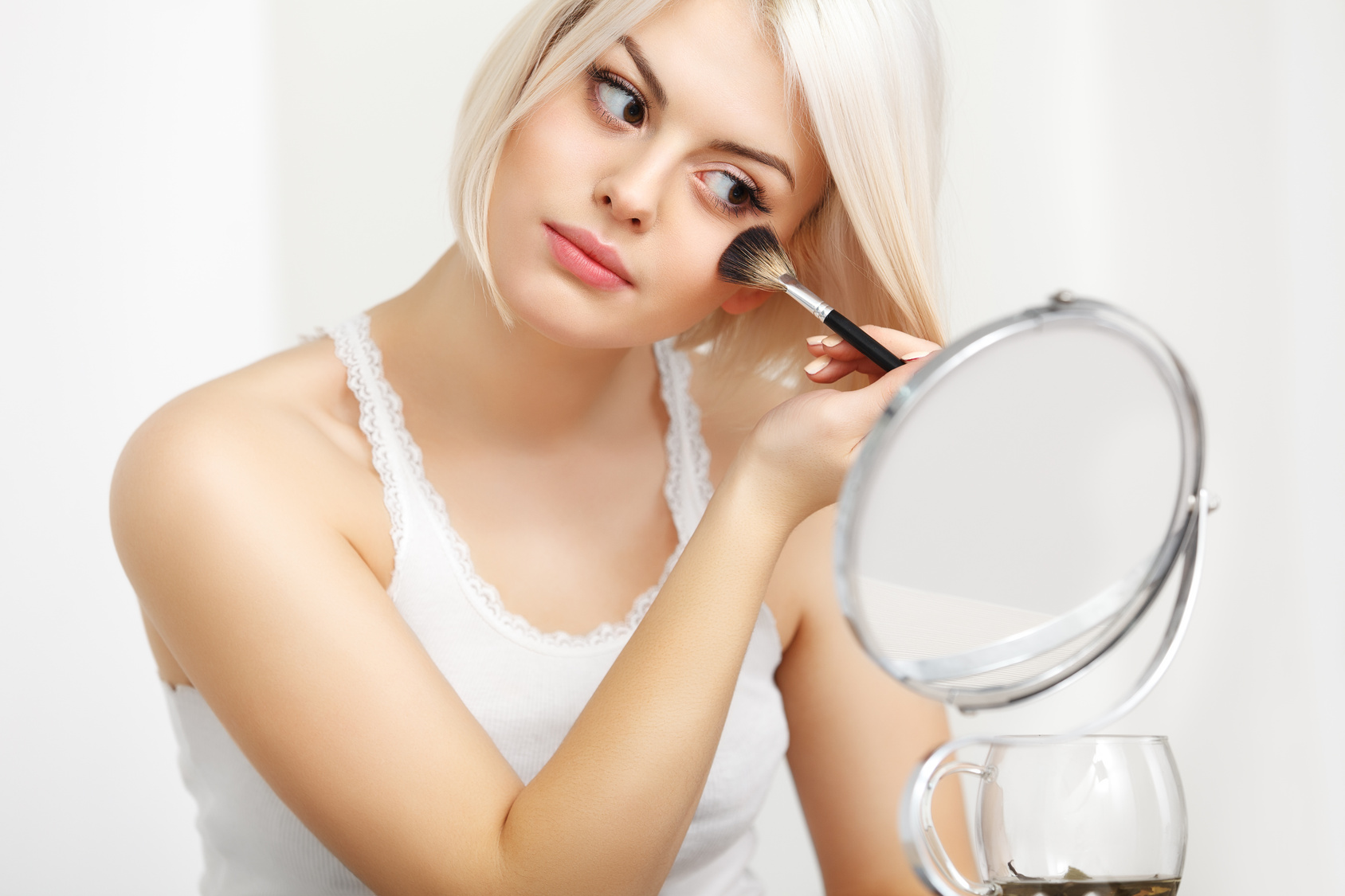 Beauty Girl with Makeup Brush. Daily Make-up for Blond Woman.