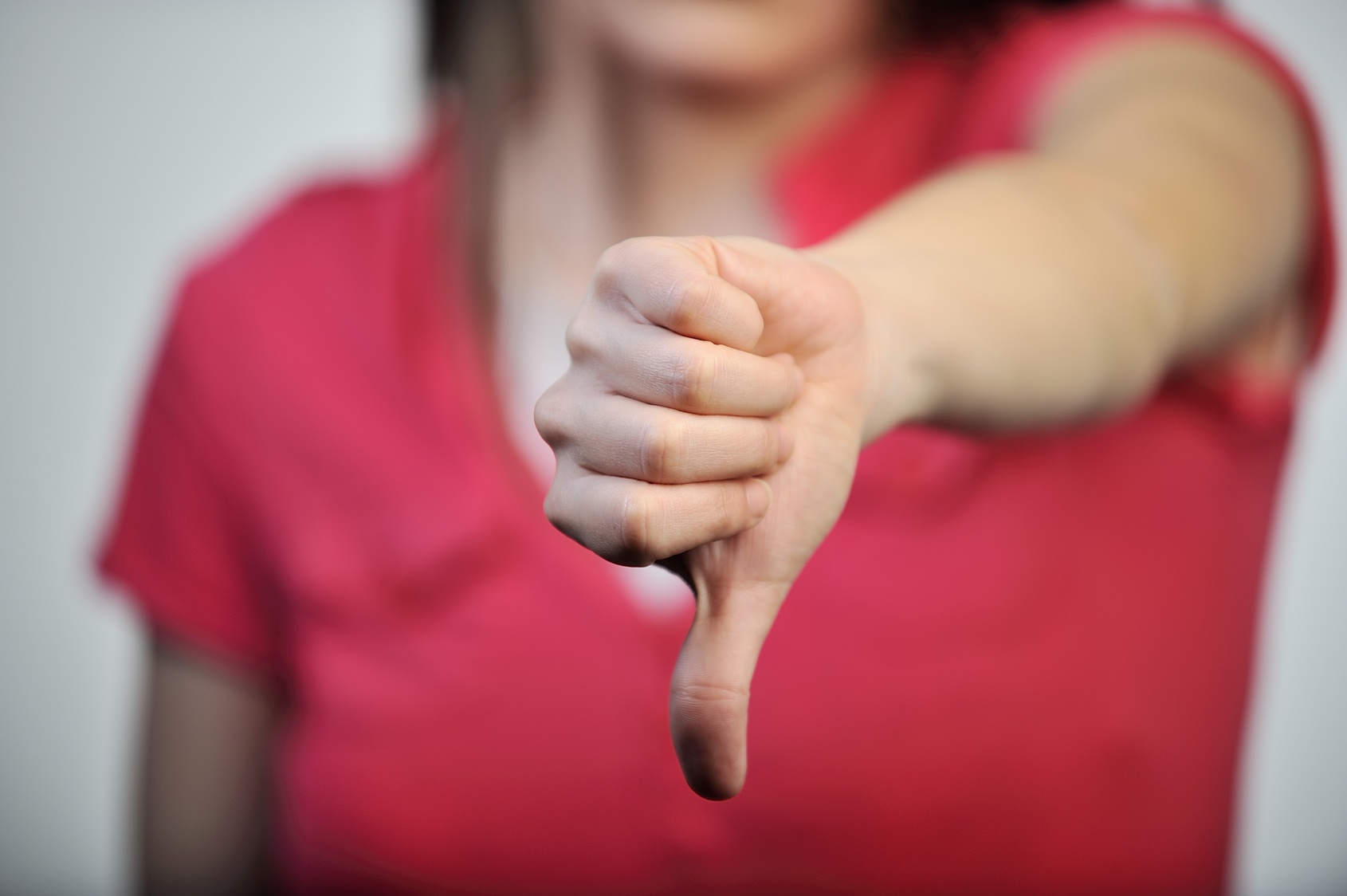 Young business woman gives a thumbs down gesture. Thumb down in