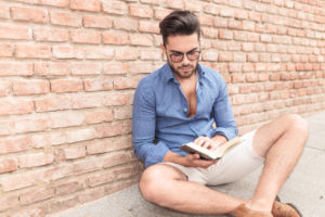 casual student reading a book while seated