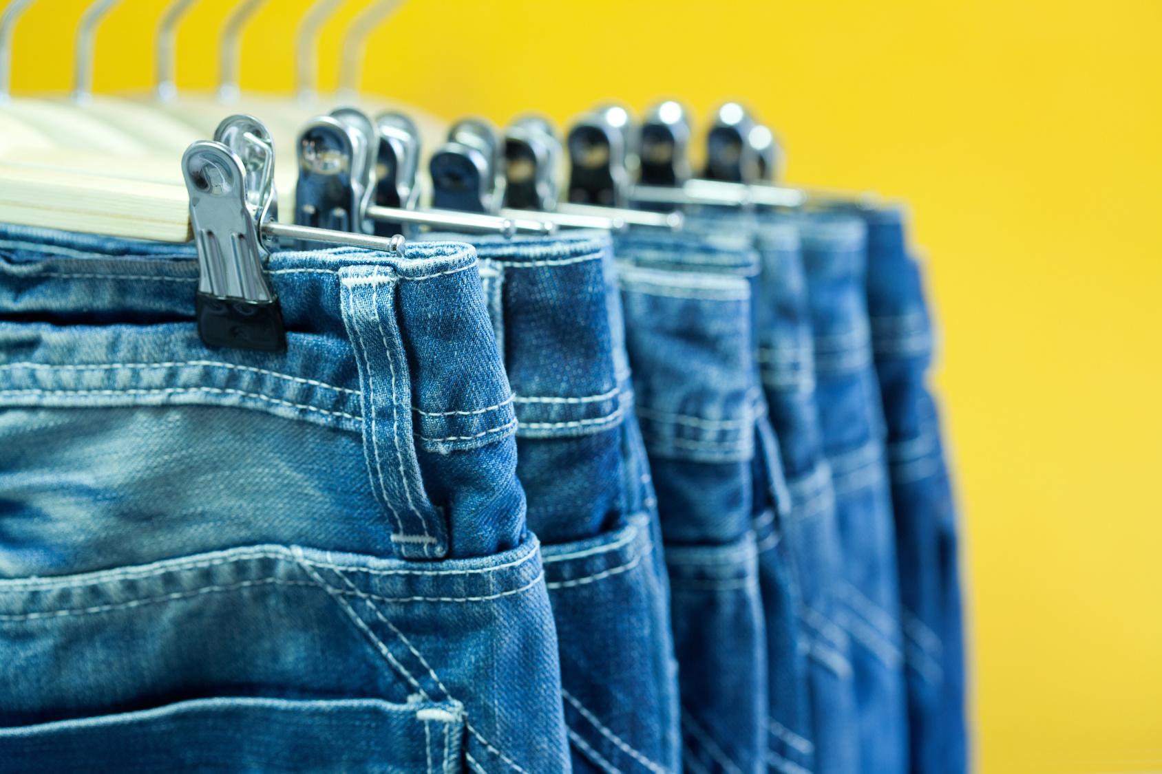 Row of hanged blue jeans in a shop