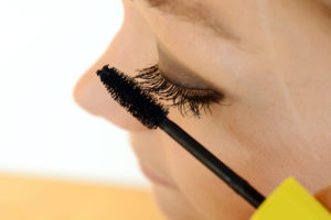 Frau schminkt Auge mit Wimperntusche