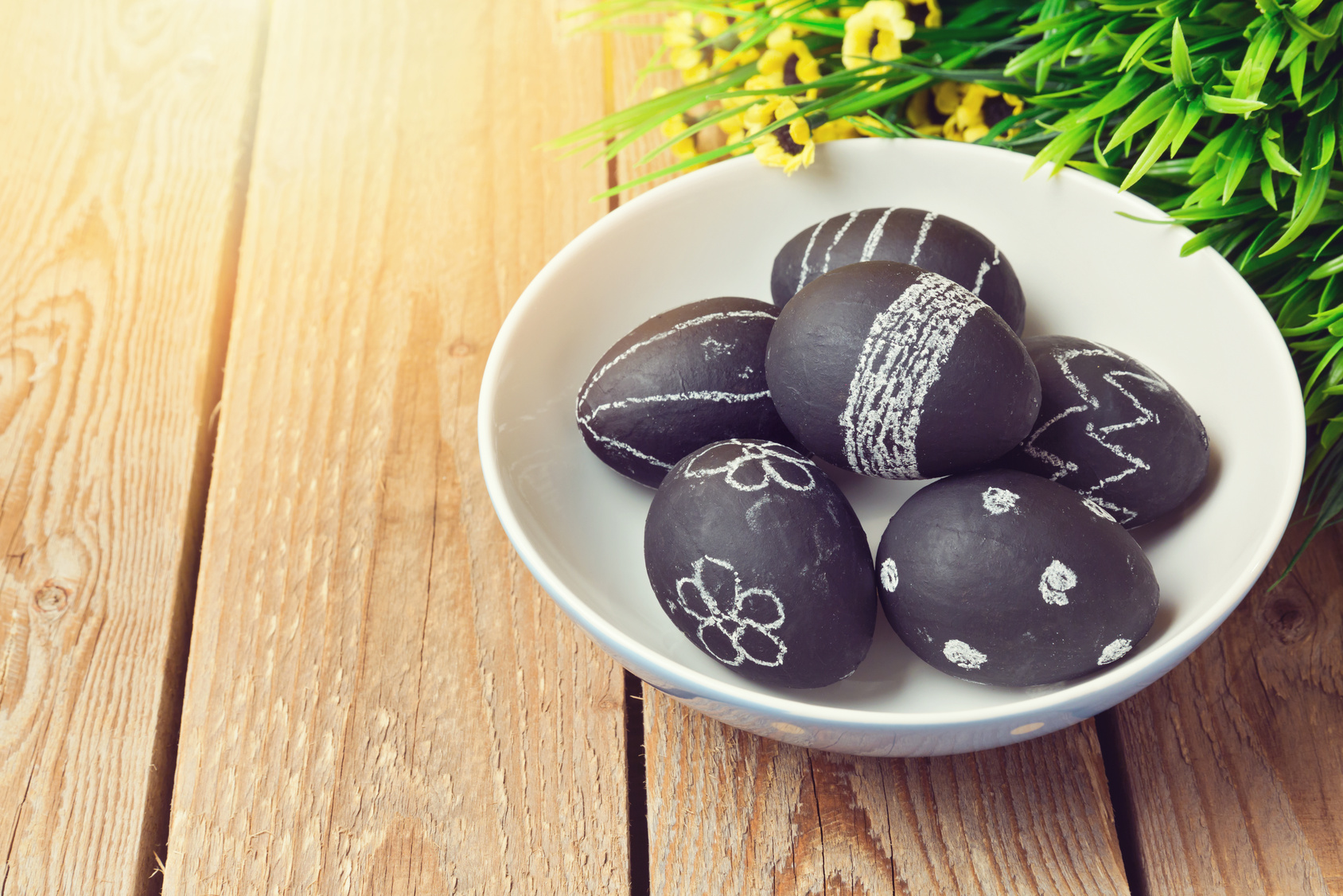 Easter eggs painted with chalkboard paint on wooden background