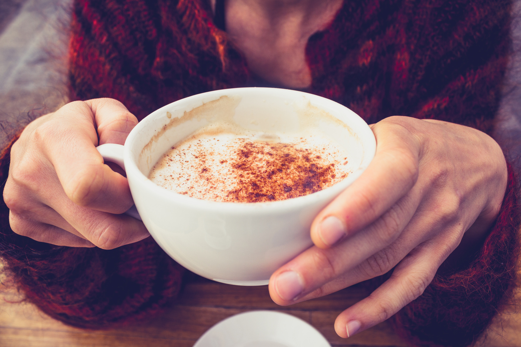 Woman in wool jumper drinking coffee on cold day