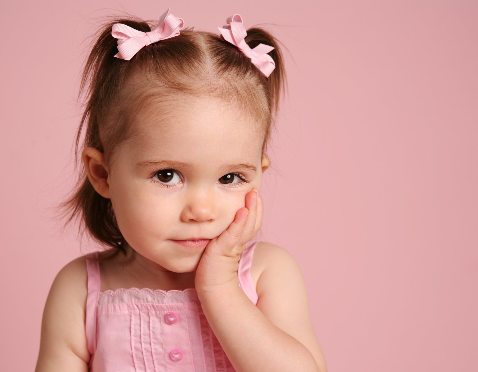 Cute toddler girl posing on pink