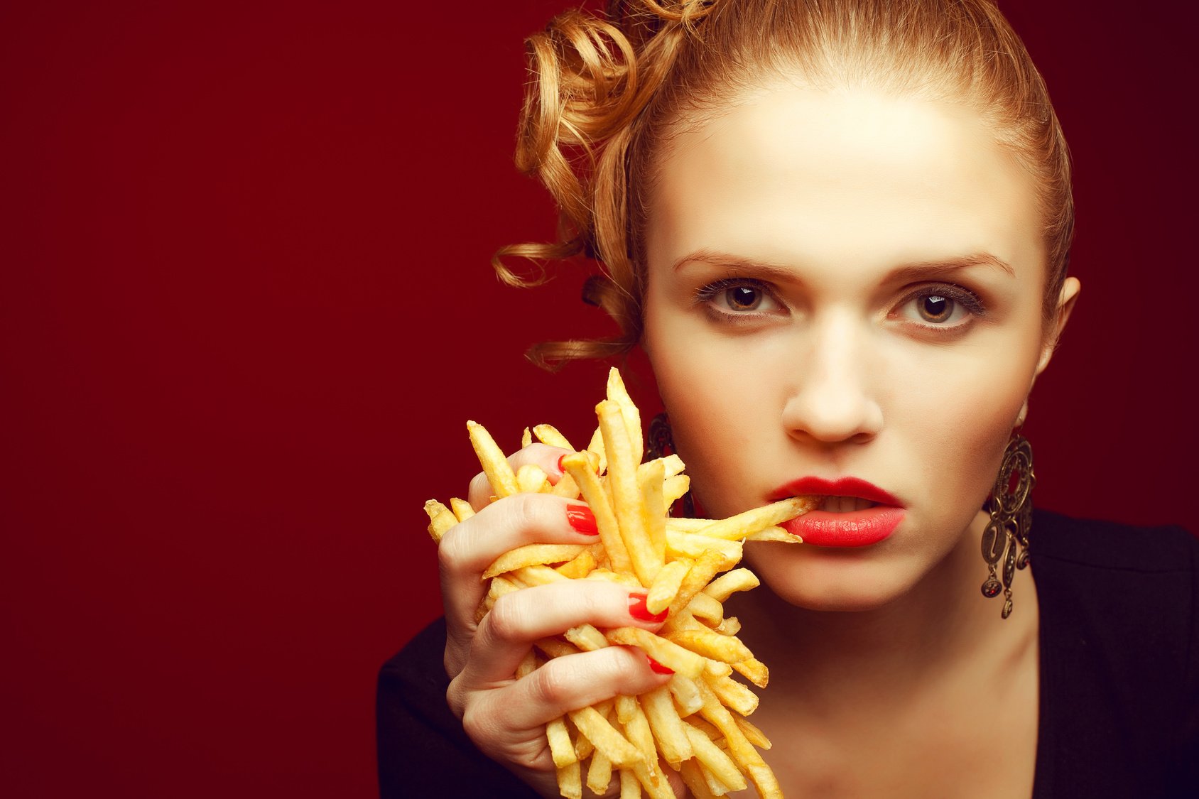 Unhealthy eating. Junk food concept. Woman eating fries