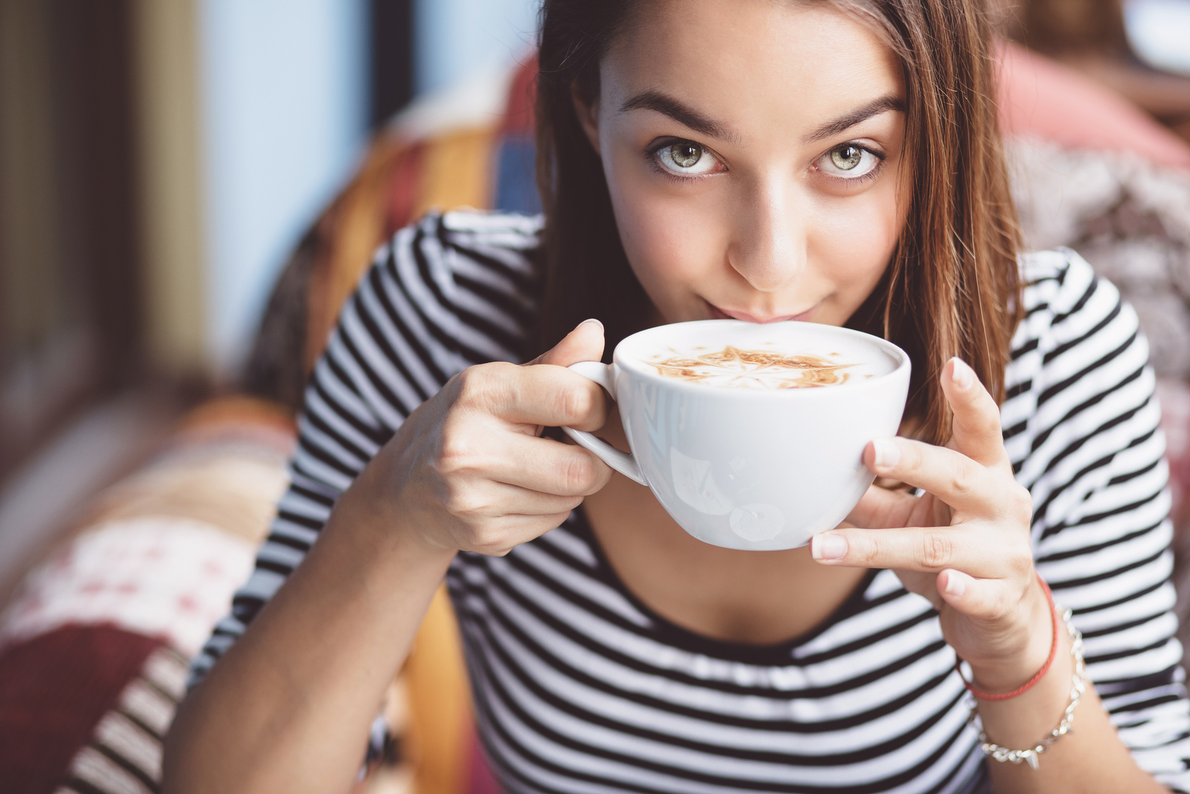 Young woman drinking coffee in urban cafe