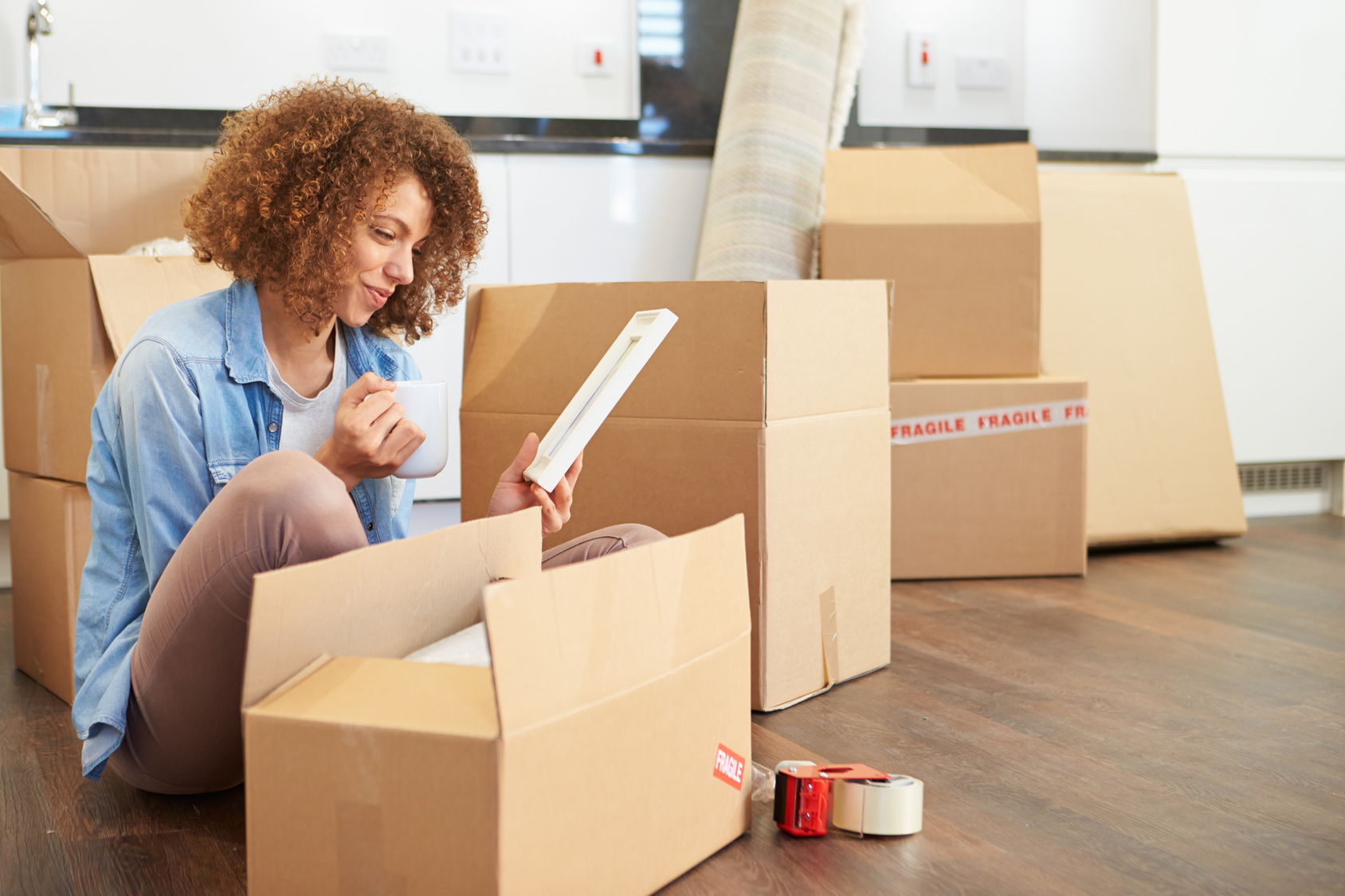 Woman Moving Into New Home And Unpacking Boxes